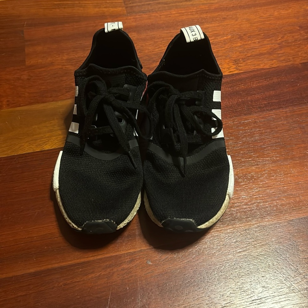 black adidas NMD with pink accents